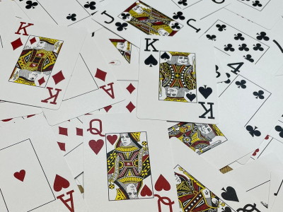 pack of playing cards spread out showing all suits hearts spades diamonds clubs